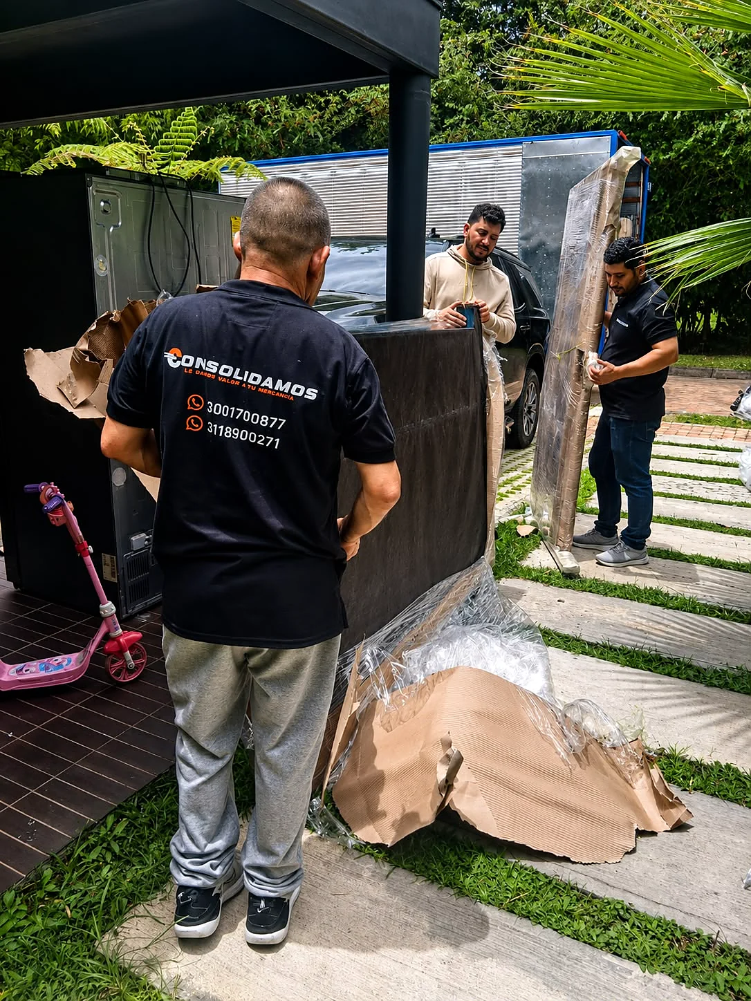 Equipo de Consolidamos embalando una nevera y muebles